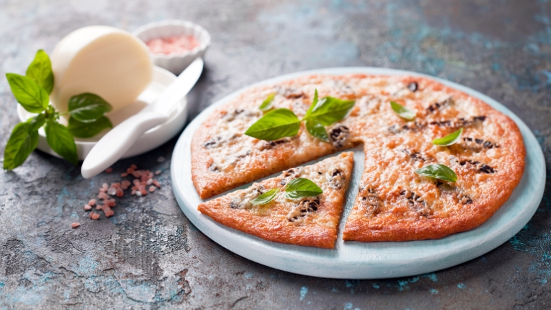 Keto pica bez belog brašna, sa sirom i bosiljkom, na svetlom tanjiru